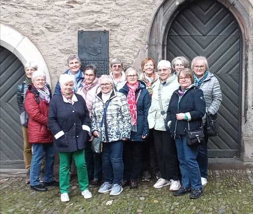 Frauengruppe vor einem historischen Portal bei der Stadtführung „Von Liebesleid und Mordgeschichten“.