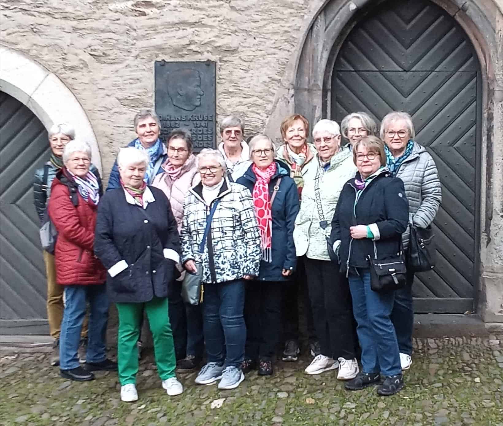 Frauengruppe vor einem historischen Portal bei der Stadtführung „Von Liebesleid und Mordgeschichten“.