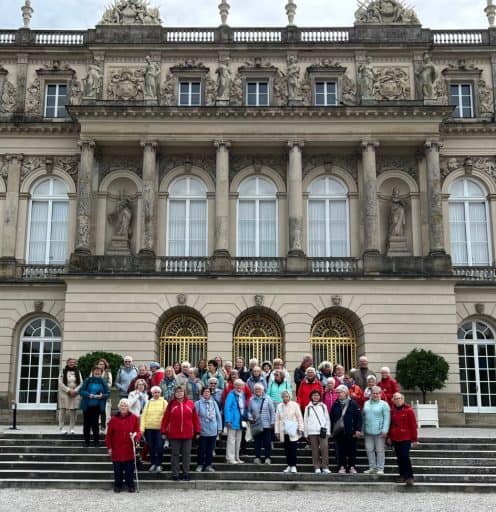 Reisegruppe der LandFrauen vor der prachtvollen Fassade von Schloss Herrenchiemsee.