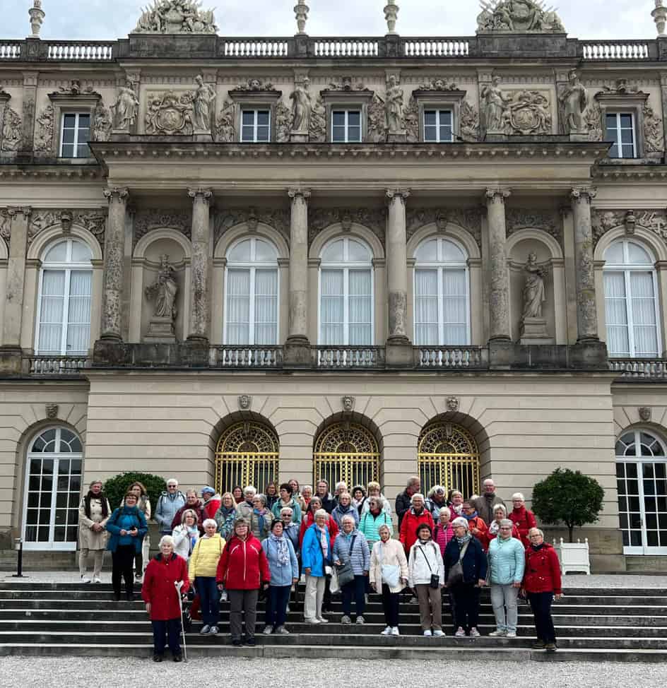 Reisegruppe der LandFrauen vor der prachtvollen Fassade von Schloss Herrenchiemsee.