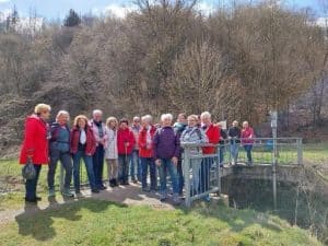 Wandergruppe der LandFrauen auf einer Brücke in der Natur während einer Frühlingswanderung.