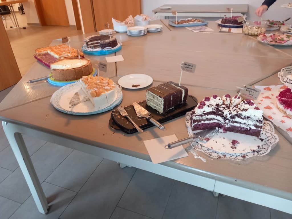 Großes Kuchenbuffet mit verschiedenen Torten und Kuchen auf Platten beim Kaffeenachmittag.