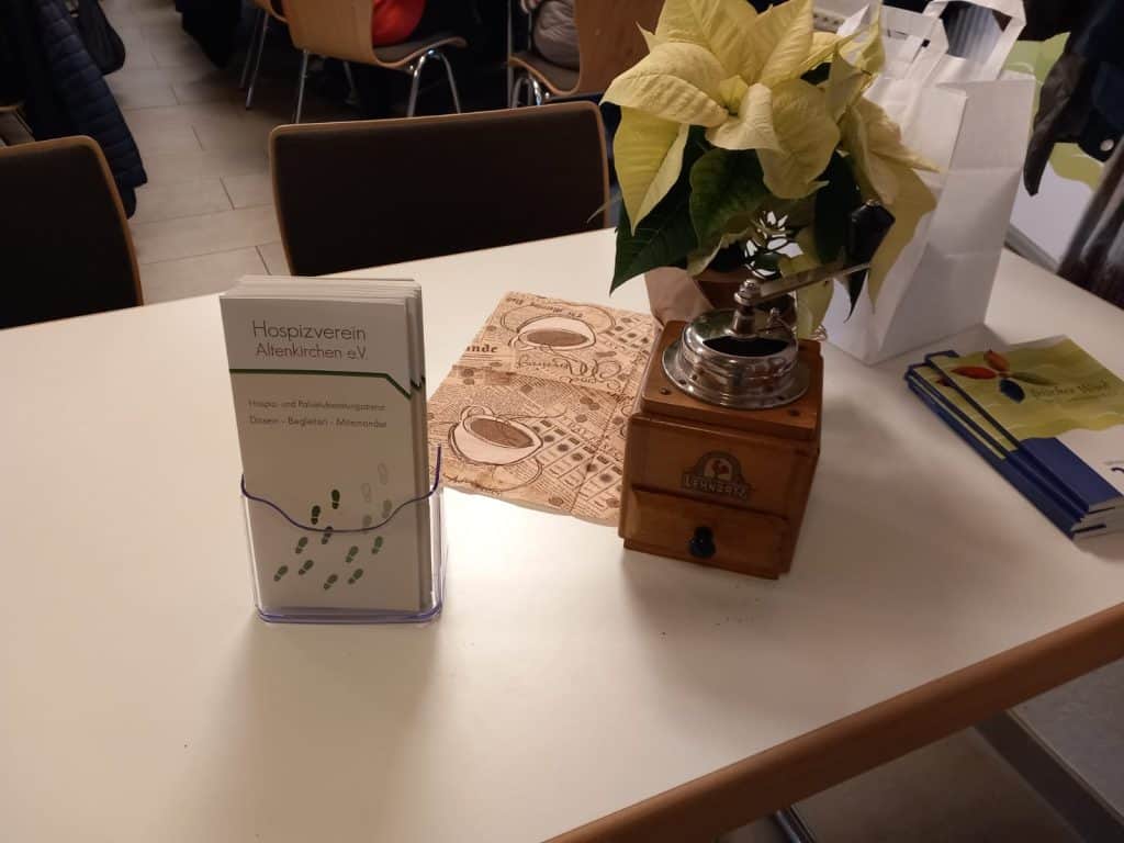 Tischdekoration beim Kaffeenachmittag mit Broschüren des Hospizvereins Altenkirchen e.V., einer Kaffeemühle und einem Weihnachtsstern.