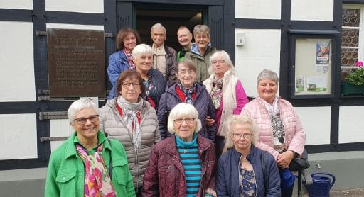 Gruppe der LandFrauen Wisserland vor einem historischen Fachwerkgebäude mit Gedenktafel.