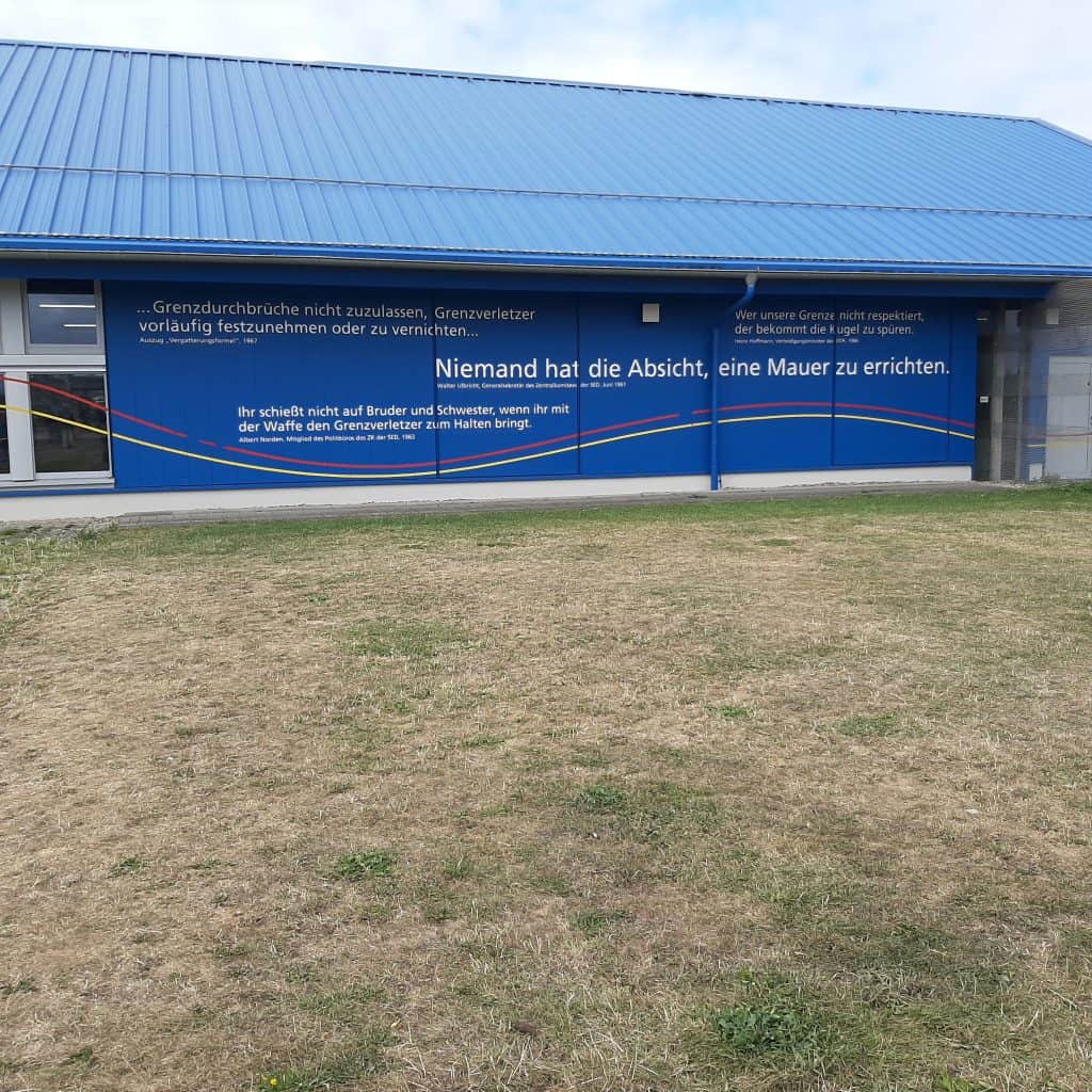 Blaues Gebäude mit Friedensbotschaften und Wandmalerei