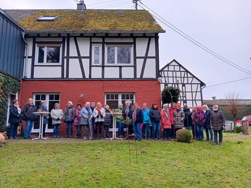 Landfrauen bei der Glühweinwanderung vor einem Fachwerkhaus
