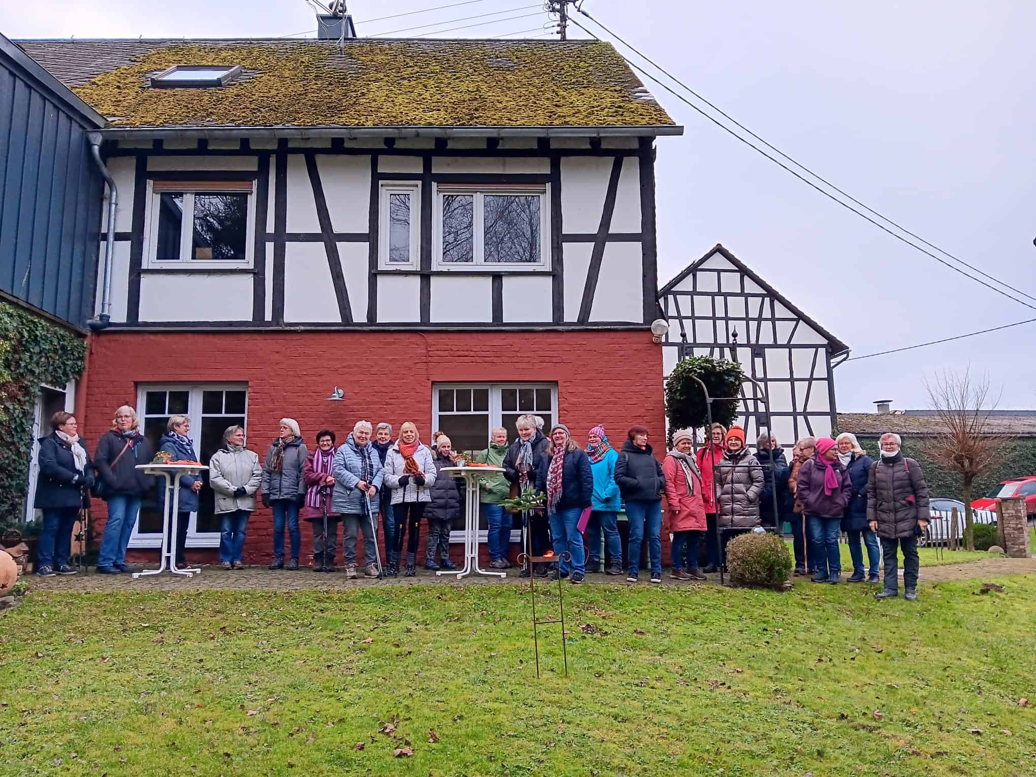 Landfrauen bei der Glühweinwanderung vor einem Fachwerkhaus
